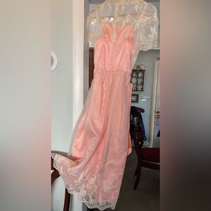 Elegant embroidered organza dress with satin sash in pale peach.